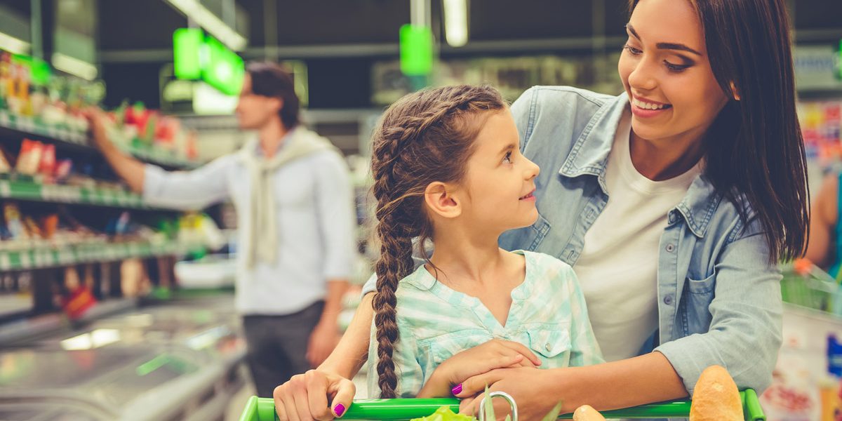 Woman buying groceries with her daughter