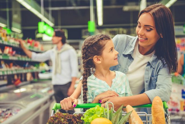 Woman buying groceries with her daughter