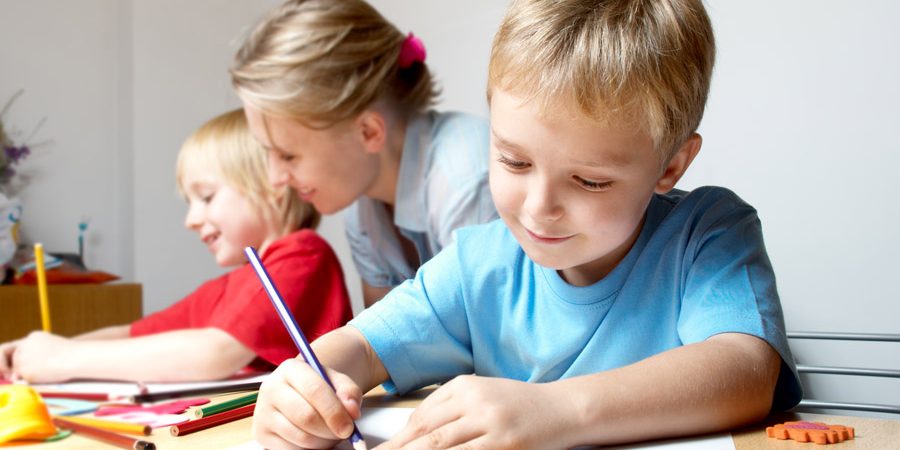 A boy drawing on a wooden table